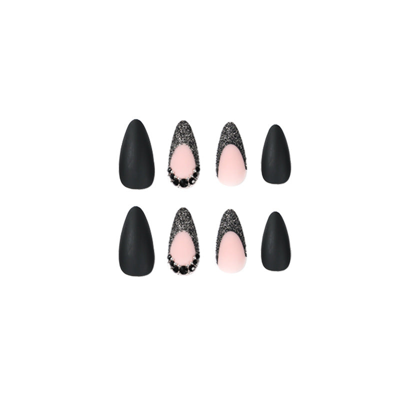 Kunstvolle Stiletto-Nägel mit elegantem Schwarz-Design und Glitzerakzenten Brehn