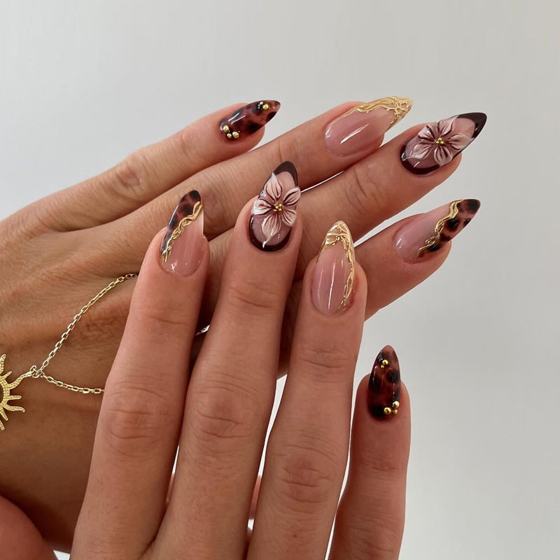 Dekorative Stiletto Press-On Nägel mit floralen und goldenen Akzenten Brehn