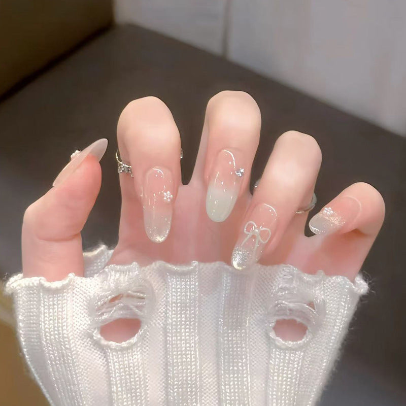 Dekorative Press-On Nagelkunst mit Schleifen- und Edelsteinakzenten Brehn