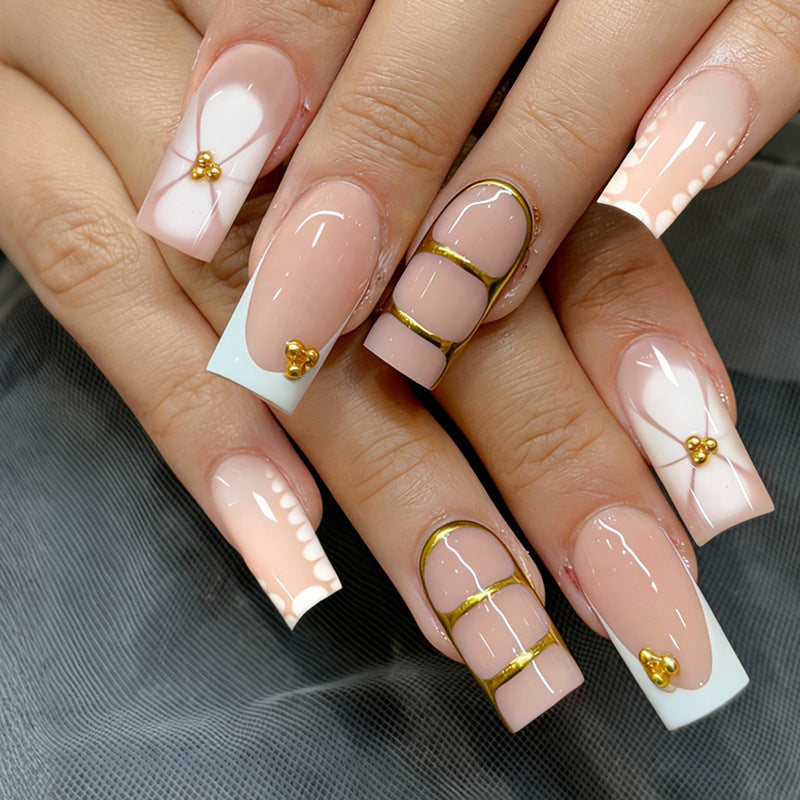 Kunstnagelset mit eleganten Goldverzierungen und romantischen Akzenten Brehn