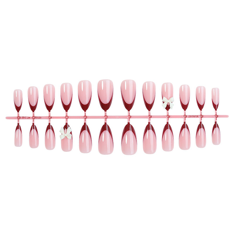 Kunstnagelset mit kreativem French-Tip Design und niedlichen Schleifen Brehn