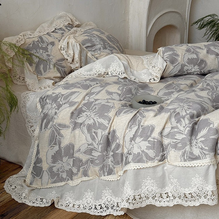 Vintage-inspirierte Baumwoll-Leinen Bettgarnitur mit großfloraler Musterung, Volant und Spitzenapplikation