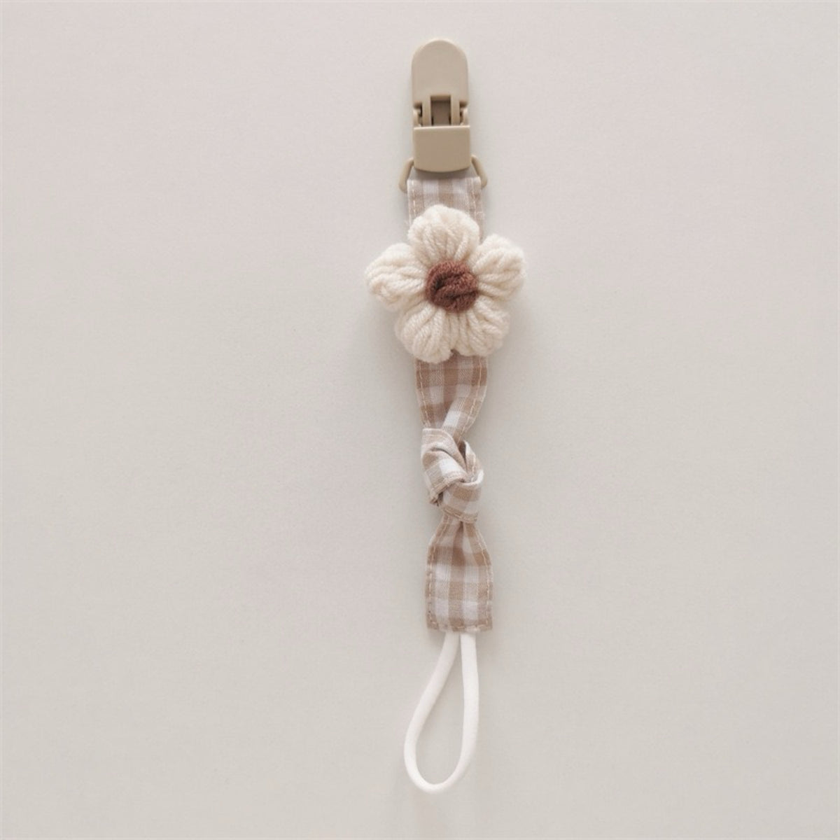 Handgemachter Baumwoll-Schnullerclip mit Gingham-Gurt und gestrickter Blume