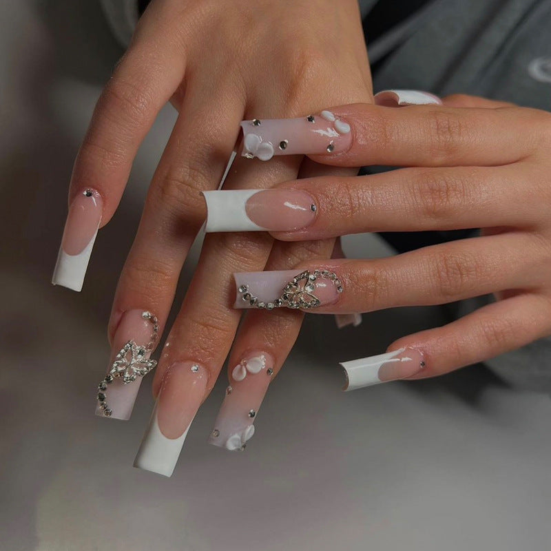 Dekorative Lange Press-On Nägel mit Strass- und Blumenakzenten Brehn