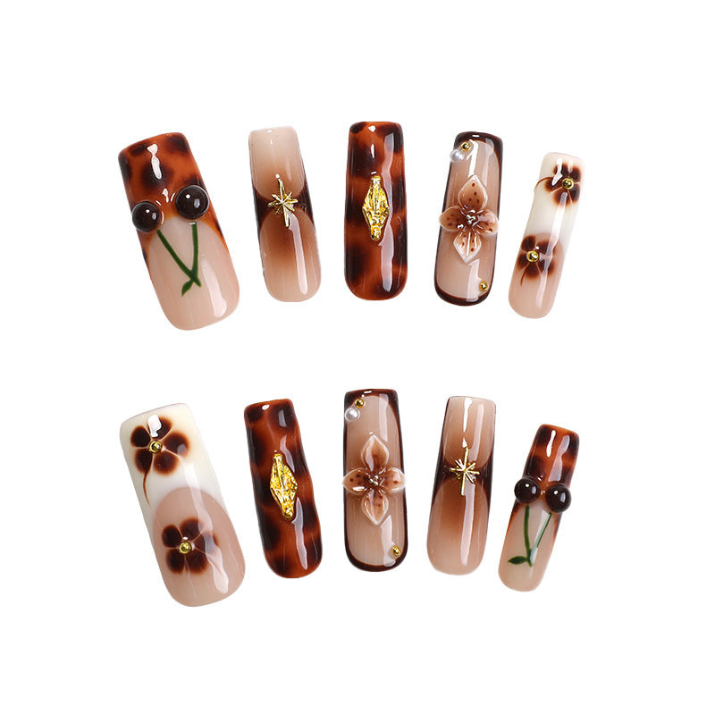 Elegantes Nagelkunstset mit floralen und goldenen Akzenten Brehn