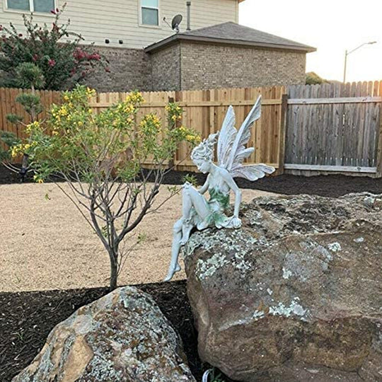 Statue einer sitzenden Fee im Garten