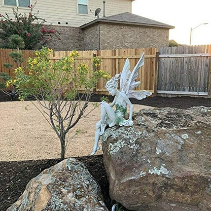 Statue einer sitzenden Fee im Garten