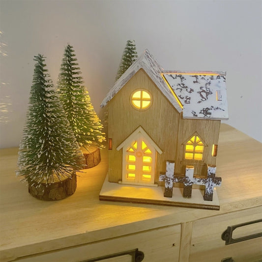 Beleuchtetes Holz-Weihnachtshaus mit Schneelandschaft