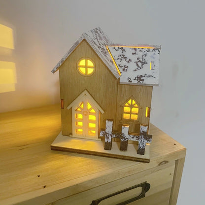 Beleuchtetes Holz-Weihnachtshaus mit Schneelandschaft
