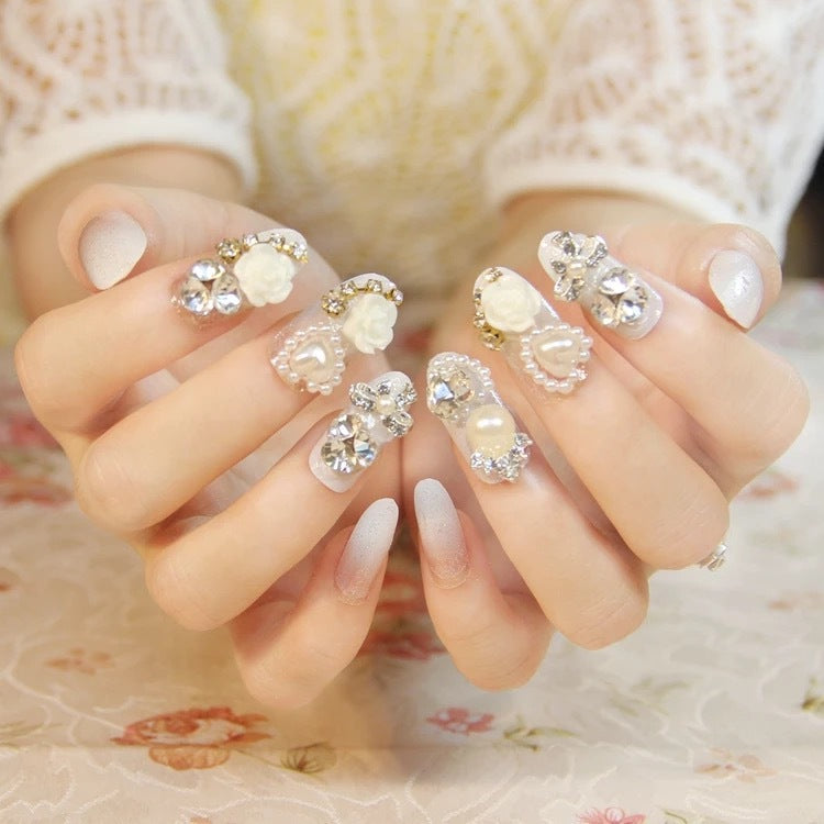 Dekorative Nagelkunst-Tipps mit Edelstein- und Perlenakzenten