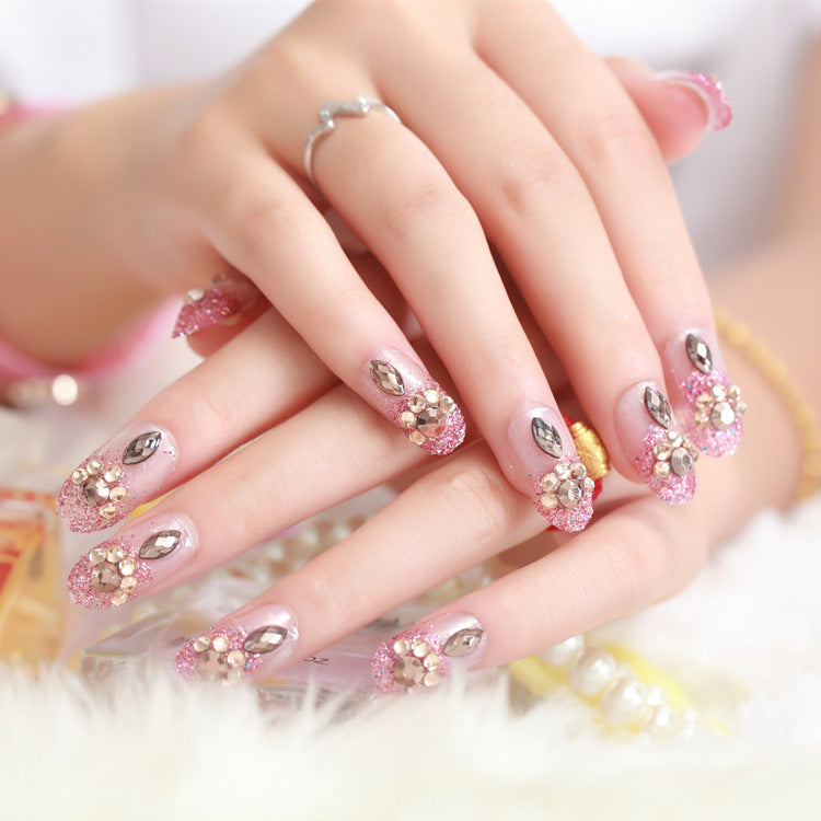 Glamouröse Kunstnägel mit Glitzer und Blumenelementen Brehn
