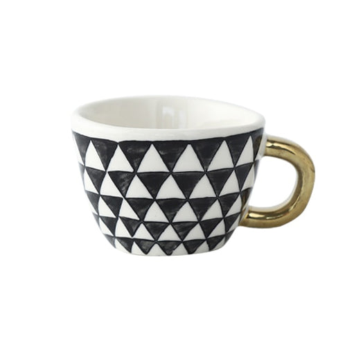 Tasse mit abstraktem geometrischen Muster und goldenem Henkel