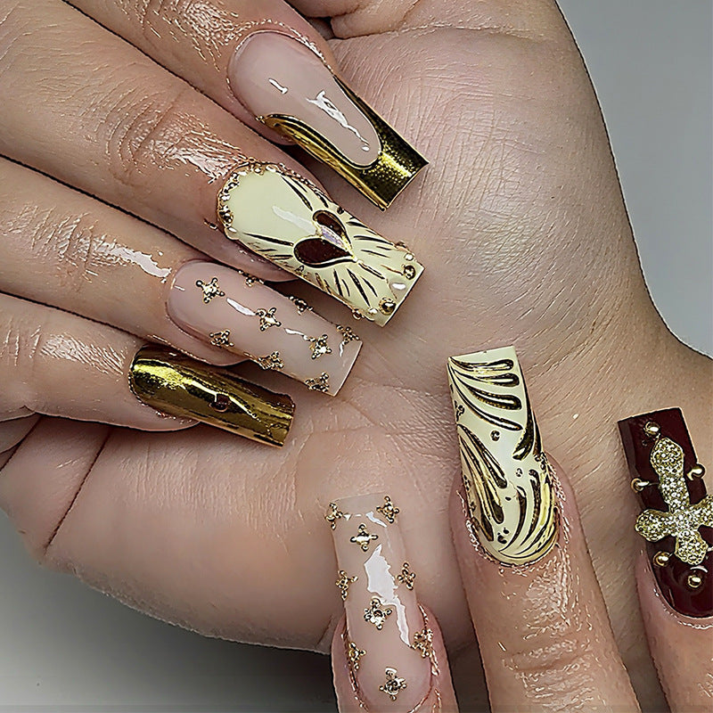 Kunstnagelset mit luxuriösen goldenen Akzenten und funkelnden Verzierungen Brehn