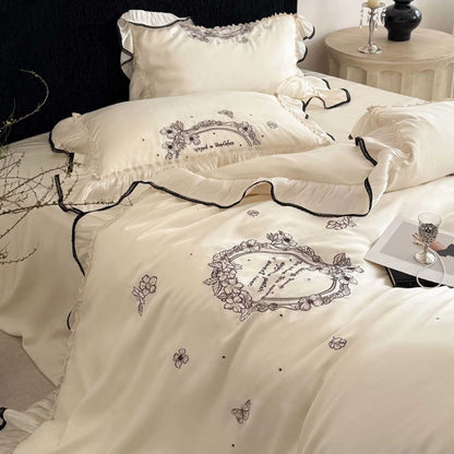 Luxuriöse Satin-Bettgarnitur mit floraler Stickbordüre und Volant