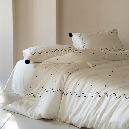 Bettwäsche-Set aus Baumwollsatin mit gewellter Stickkante und Pompon-Kissen