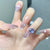 Künstlerisches Ombre Press-On Nageldesign mit Kristallakzent Brehn