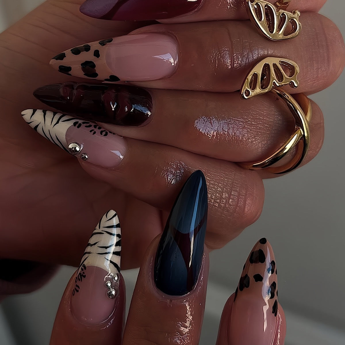Künstlerische Stiletto-Nagelverlängerungen mit trendigem Tierdruck und Schmuckakzenten Brehn