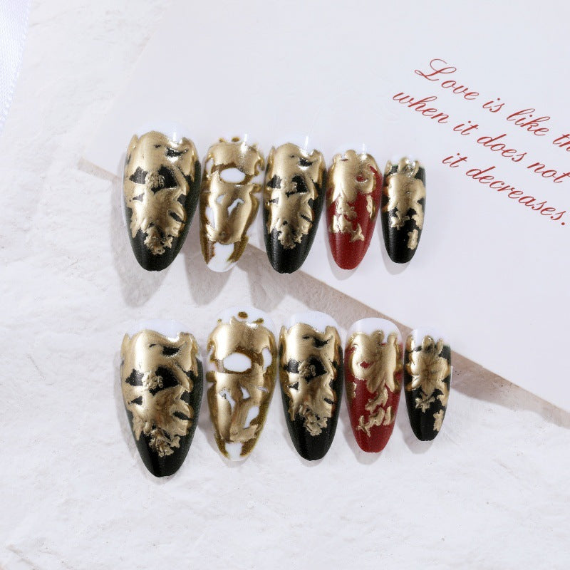 Elegante Kunstnägel mit Gold- und Schwarzmuster Brehn