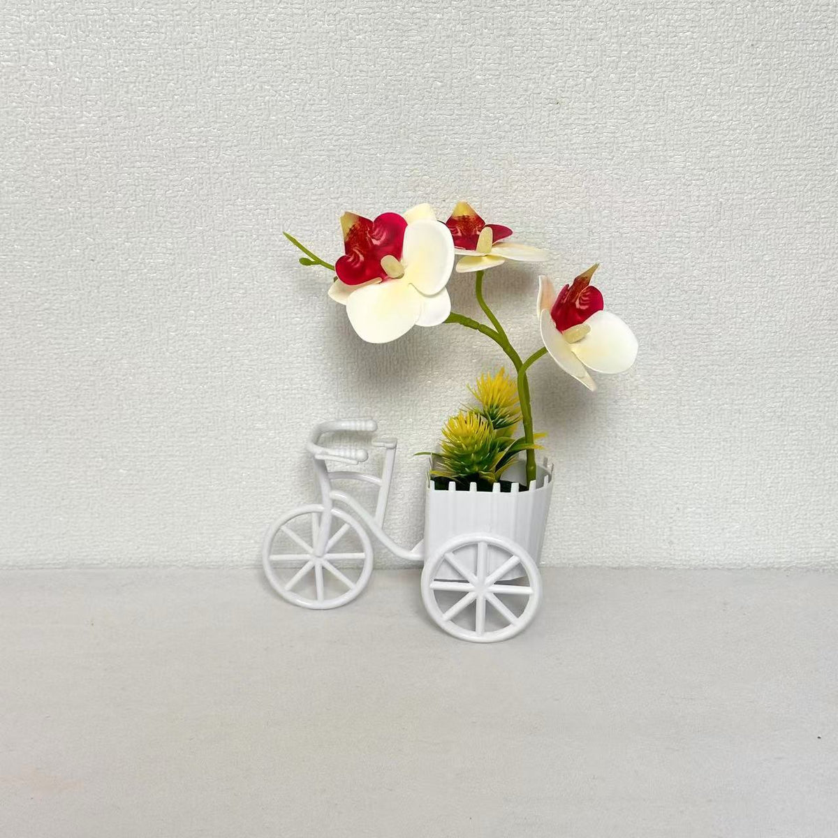 Dekorativer Fahrrad-Blumentopf mit Kunstorchideen-Arrangements für Dekor