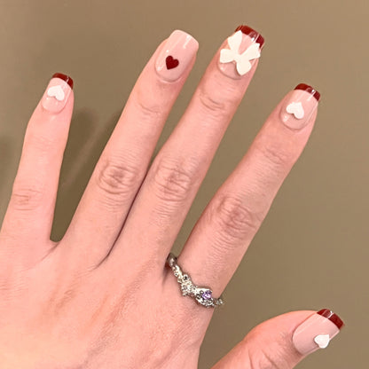 Kunstvolle Nagelkunst mit Herz- und Schleifenmotiven Brehn