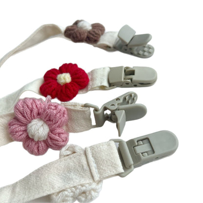 Handgemachter Baumwoll-Schnullerclip mit Gingham-Gurt und gestrickter Blume