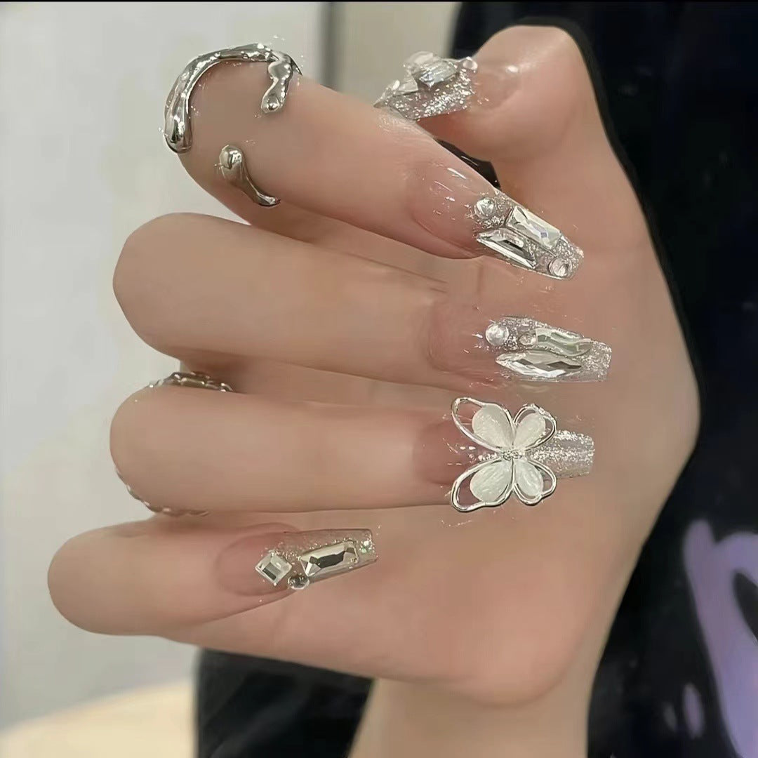 Kunstvolle Nagelkunst mit Schmetterlings- und Perlendetails Brehn
