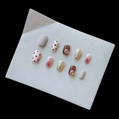 Künstlerisches Press-On-Nagelset mit Herz- und Glitzerelementen