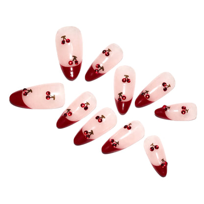 Kunstvolle Stiletto-Nägel mit Kirschmotiven und Glitzerakzenten Brehn