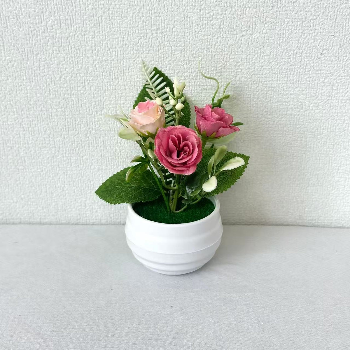 Lebensechte Blumenarrangement in dekorativem Topf für die Wohnkultur