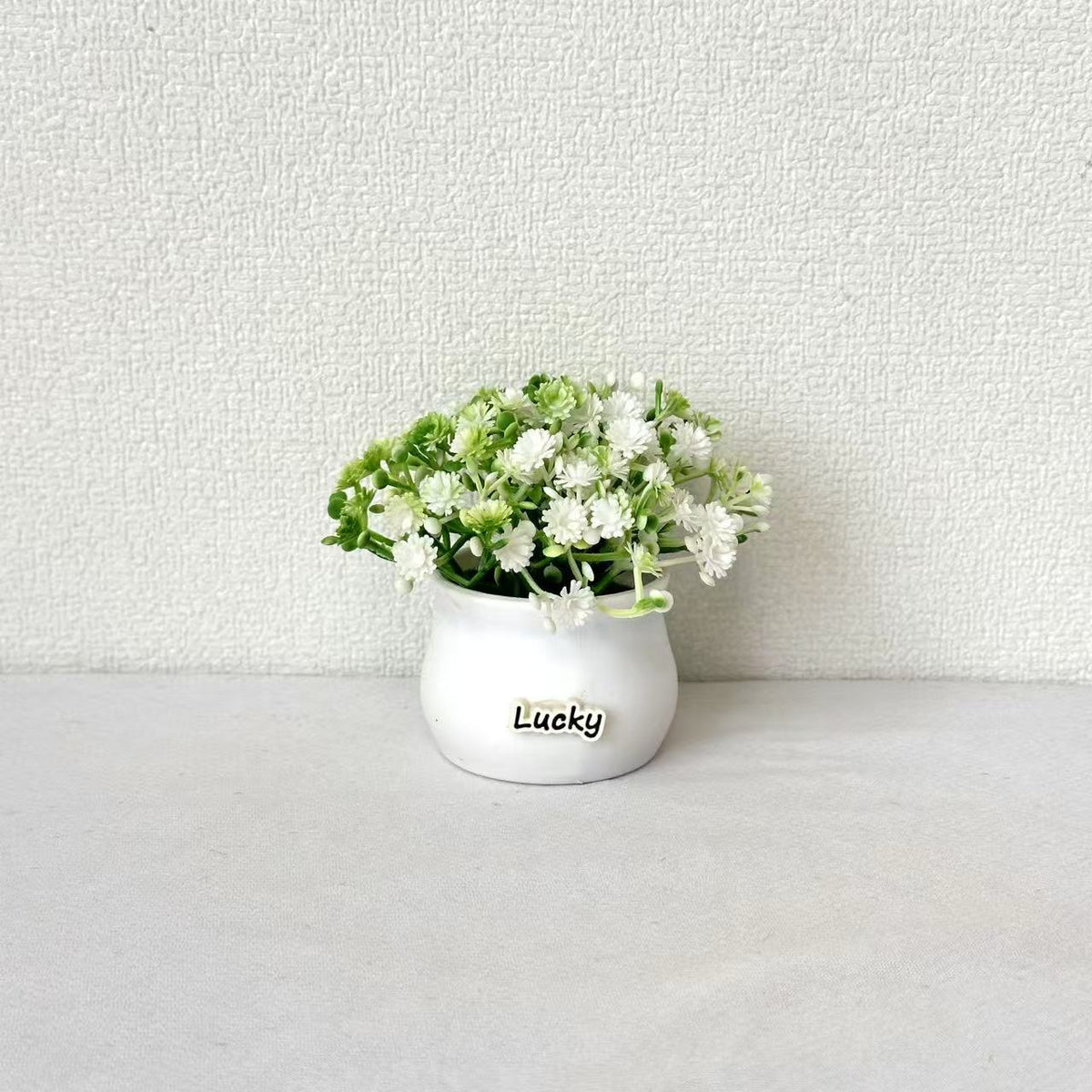 Lebensnahe Miniatur-Blumenarrangement im Topf
