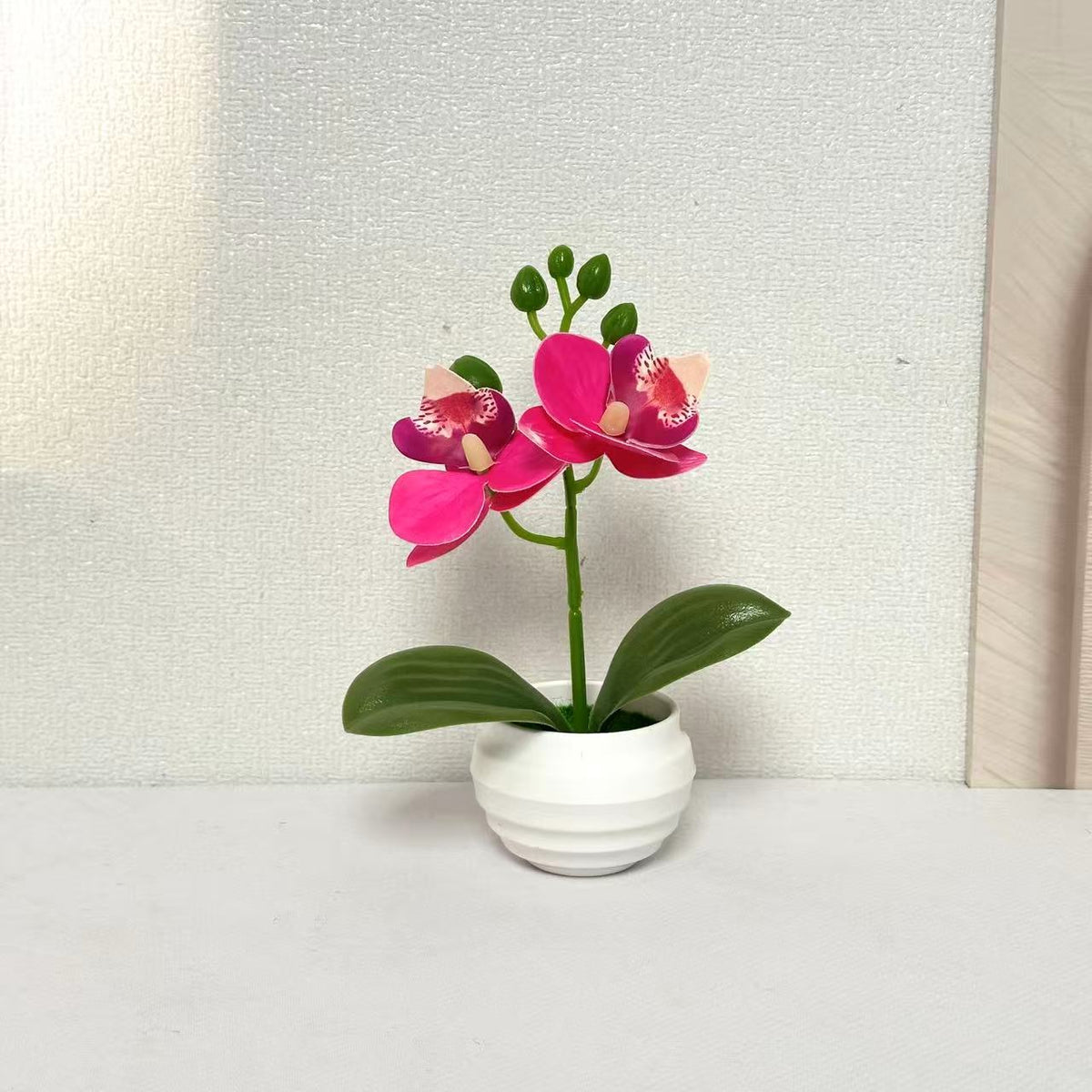 Lebensechte dekorative Orchideenpflanzenarrangement für die Wohnkultur