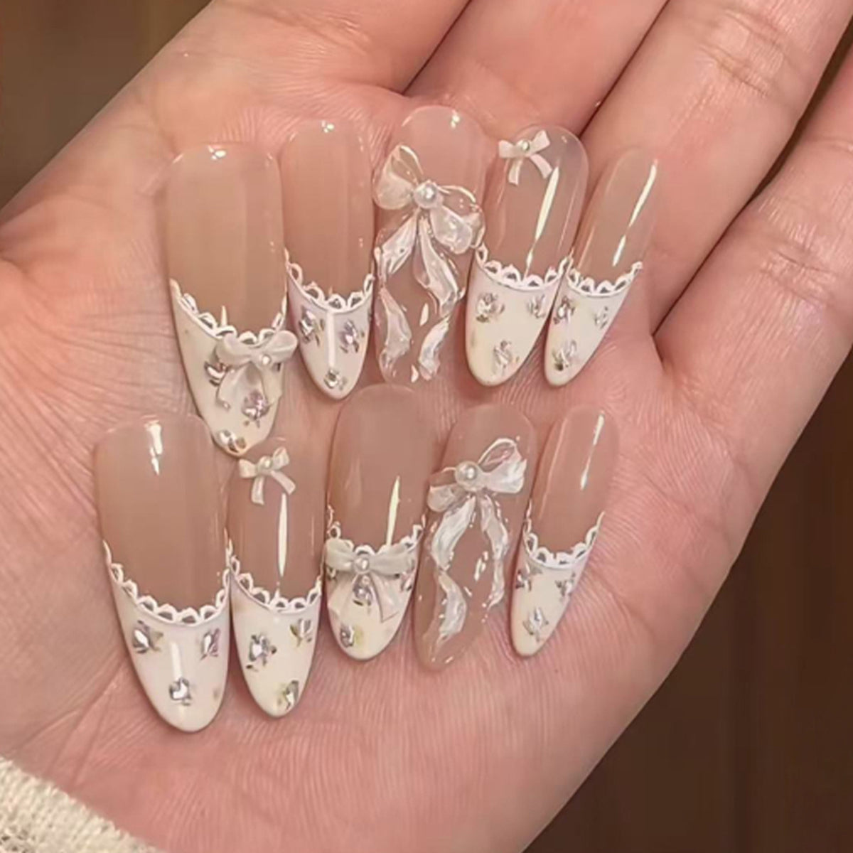 Kunstvolle Nagelkunst mit eleganten Schleifen und Strass-Details Brehn
