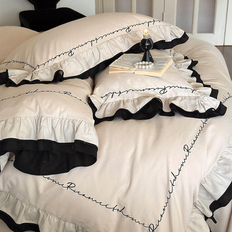 Luxuriöse Baumwoll-Satin-Bettwäschegarnitur mit Volant, kontrastierender Paspel und kalligrafischer Stickschrift
