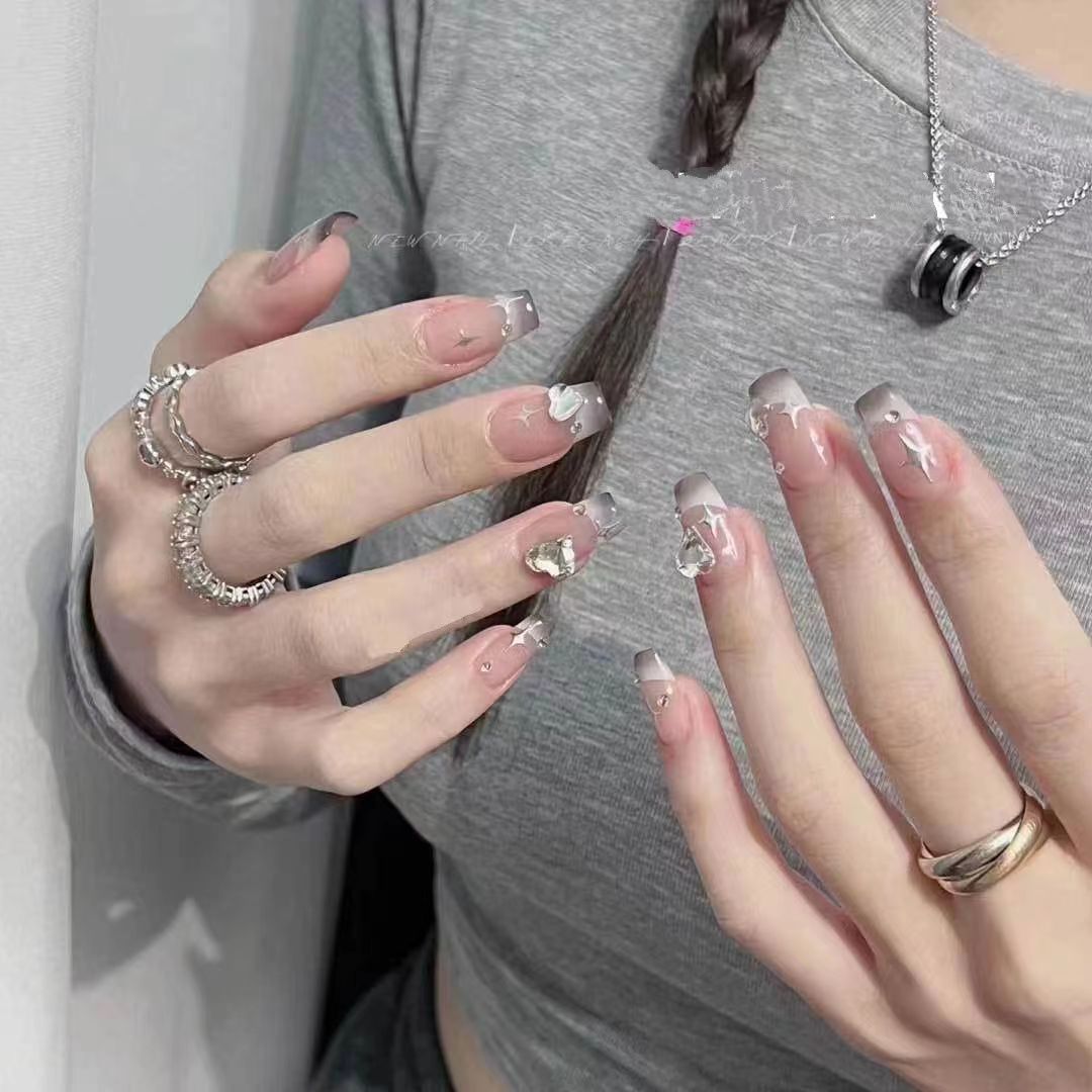 Kunstvolle Nagelkunst mit Schmetterlings- und Perlendetails Brehn