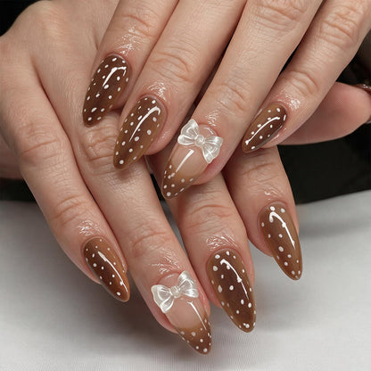 Kunstvolle Stiletto-Nägel mit zartem Schleifenmotiv Brehn