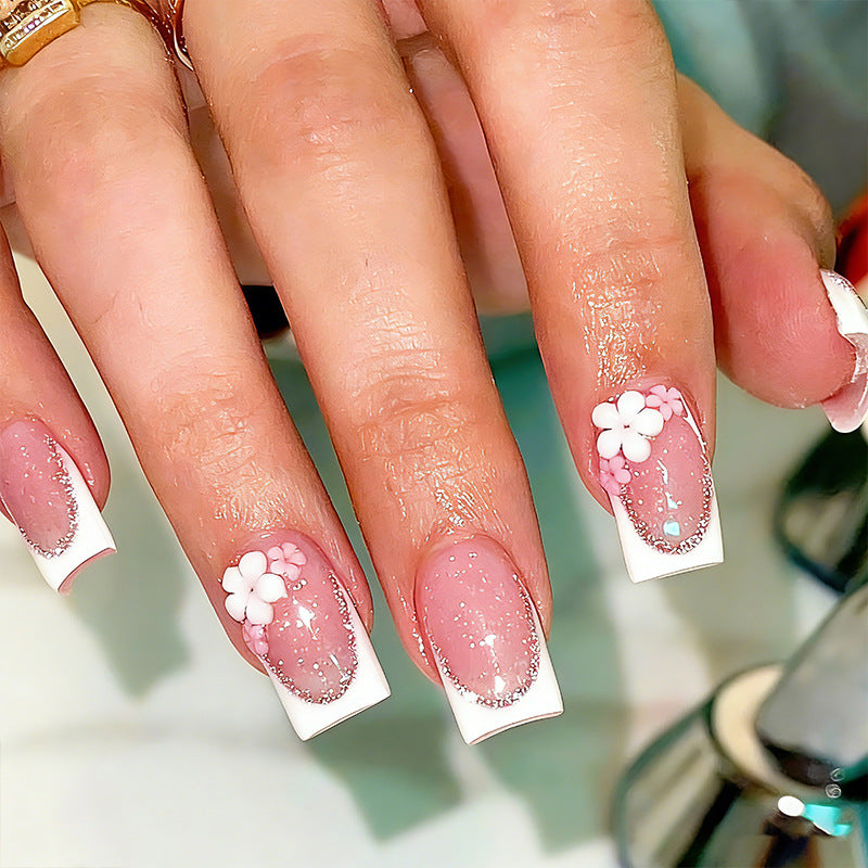 Kunstnagelset mit elegantem French-Tipp und filigranen Blütenverzierungen Brehn