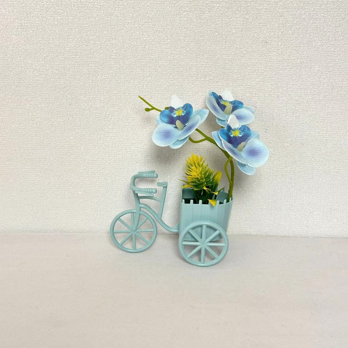 Dekorativer Fahrrad-Blumentopf mit Kunstorchideen-Arrangements für Dekor