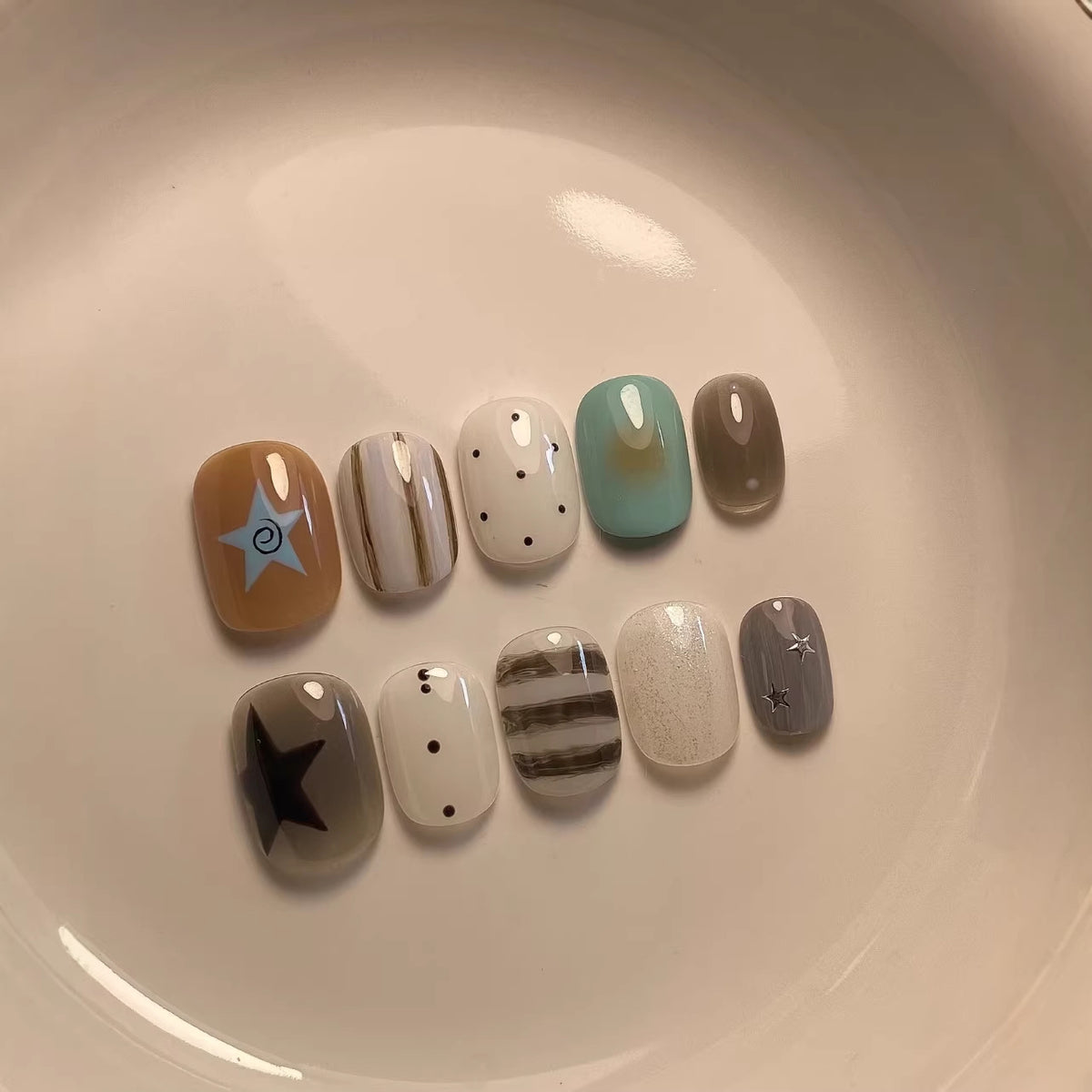 Künstlerisches Press-On Nagelset mit geometrischen und Stern-Designs
