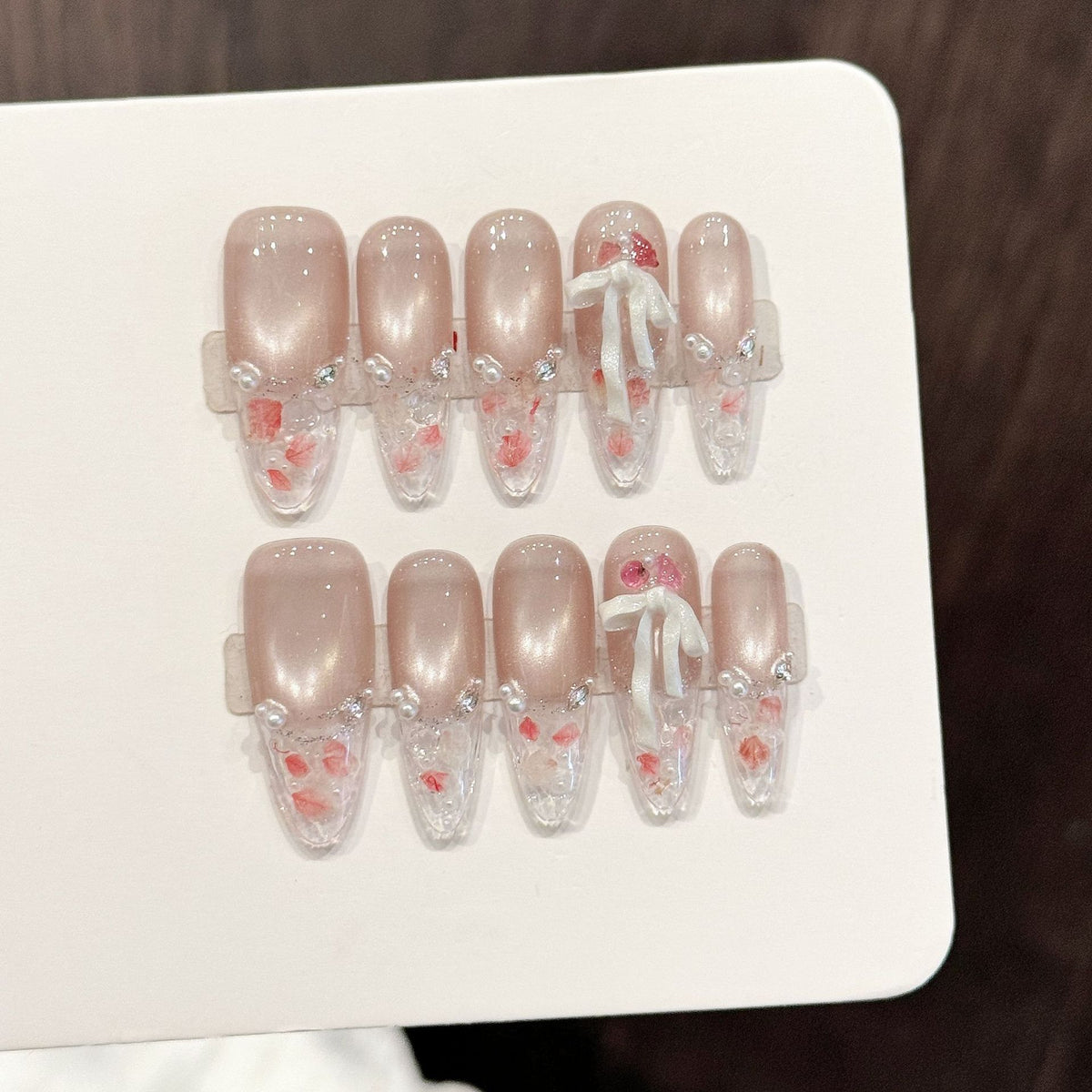 Dekoratives Press-On Nagelkunstset mit eleganten Perlen- und Schleifenelementen