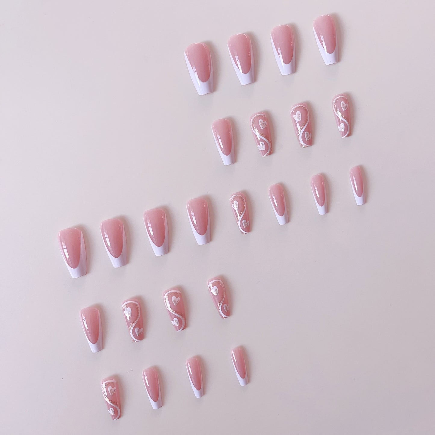 Kunstnagelset mit eleganten Herzverzierungen und Glitzerakzenten Brehn