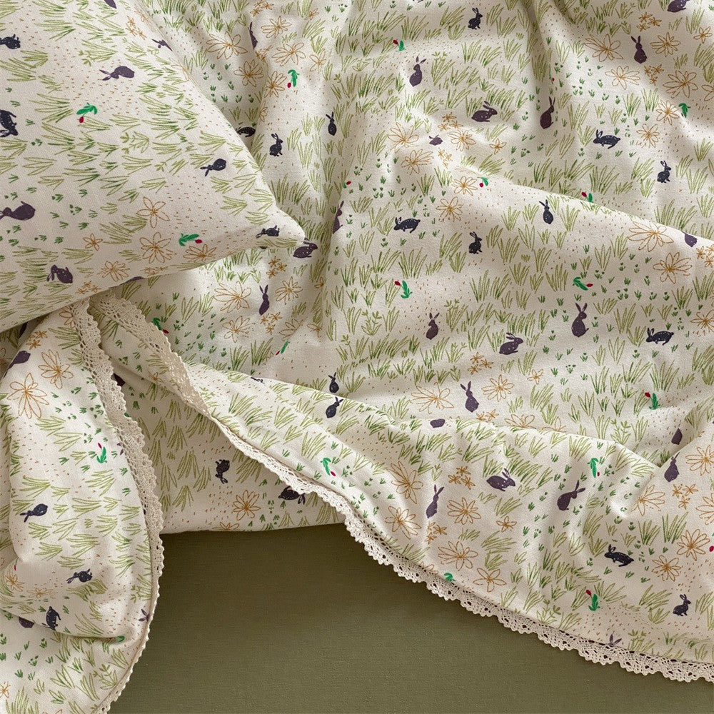 Gesteppte Wohndecke aus Baumwoll‑Mischgewebe mit zartem Blumenmuster und Spitzenkante