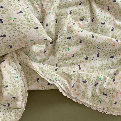 Gesteppte Wohndecke aus Baumwoll‑Mischgewebe mit zartem Blumenmuster und Spitzenkante
