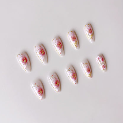 Kunstnägel mit floralen Akzenten und goldenen Details Brehn