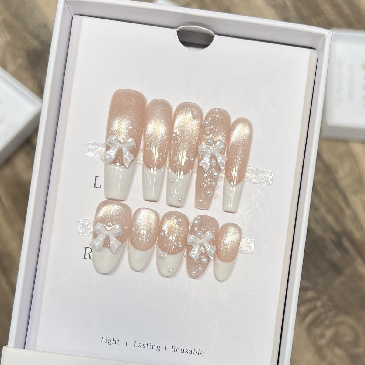 Dekorativer langer Press-On-Nagelset mit Schleife und Perlenakzenten Brehn