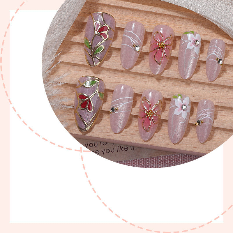 Kunstnagelset mit filigranen floralen Verzierungen und glänzenden Details Brehn