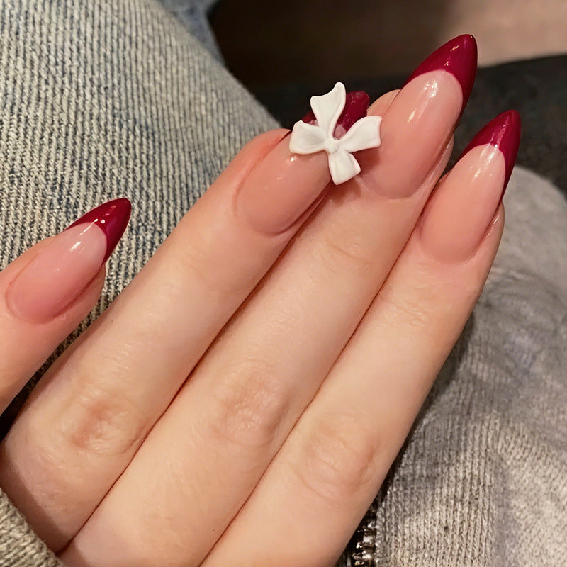 Kunstnagelset mit kreativem French-Tip Design und niedlichen Schleifen Brehn