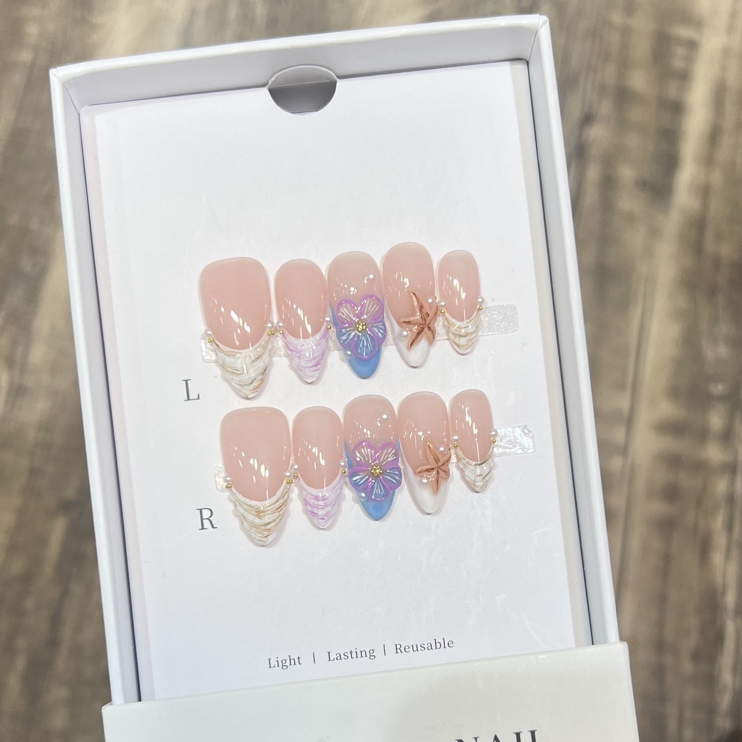 Künstlerisches Press-On Nagelkunst Set mit floralem und Seestern Design Brehn