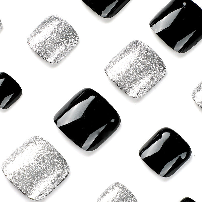 Kunstvolle Fußnagelkunst mit Glitzer- und Schwarzdesign Brehn