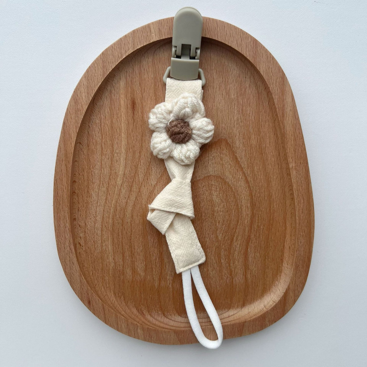 Handgemachter Baumwoll-Schnullerclip mit Gingham-Gurt und gestrickter Blume
