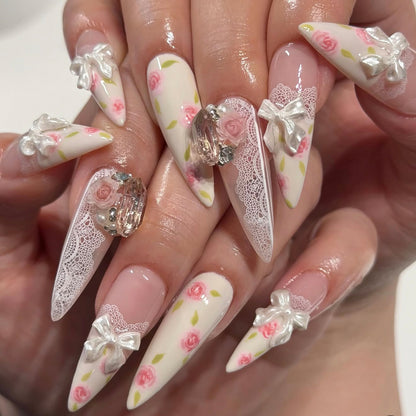 Kunstvolle Stiletto-Nägel mit floralen Akzenten und Glitzerakzenten Brehn
